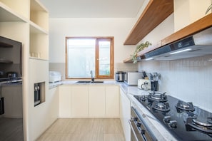 A modern kitchen with a built-in oven, a microwave, and a gas stove.