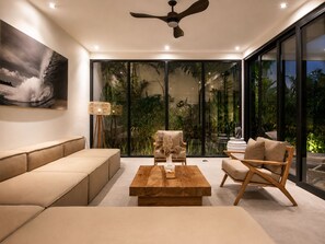 A modern living room with a sofa, a wooden coffee table, and a chair. - Elegant 5BR Villa Retreat Steps From Canggu Beach (Munggu)