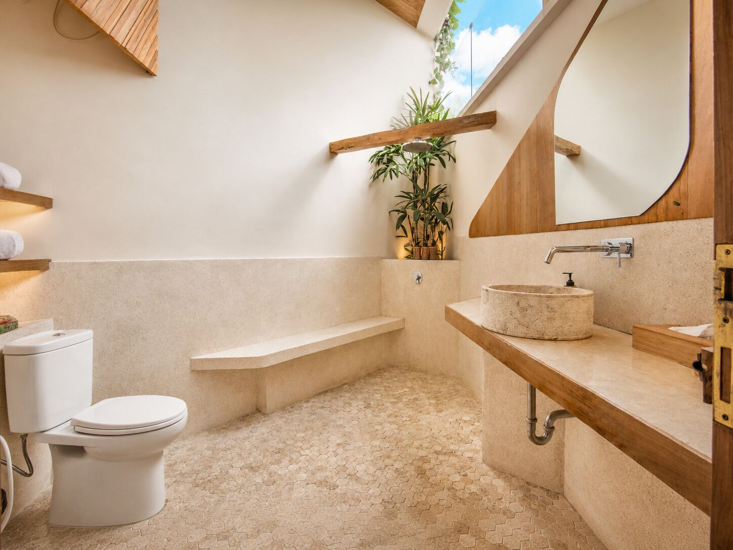 Un baño moderno con inodoro, lavamanos y zona de ducha.