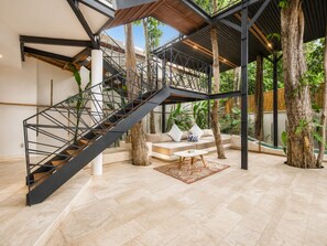 A modern interior with a staircase, a sofa set, and a coffee table.