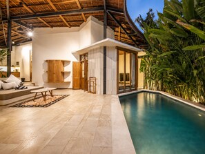 A modern interior with a pool, wooden furniture, and tropical plants. - Lush 1-br Villa With Pool, 4 Mins to Echo Beach, (Canggu)