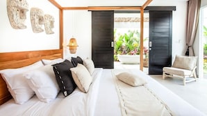 Ein modernes Schlafzimmer mit einem großen Bett, einem Holz-Kopfteil und Blick auf einen Garten durch eine offene Tür.
