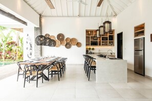 A modern kitchen with a central island, pendant lights, and a built-in refrigerator. - Modern 4 BR Villa 400m to the Beach in Canggu (Canggu)