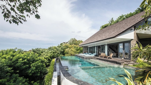 A modern house with a swimming pool surrounded by lush greenery. - Elegant 6BR Clifftop Villa Near Bingin (Pecatu)