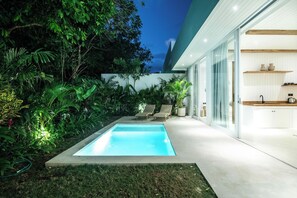 A modern house with a swimming pool, lush greenery, and a minimalist interior.