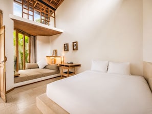Une chambre à coucher comprenant un lit, un bureau, une chaise et une fenêtre donnant sur un espace verdoyant.