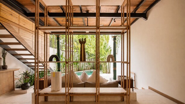 A room with a wooden partition, a staircase, and a view of a pool. - Stylish 1-br Villa With Pool, 800m to Echo Beach (Canggu)