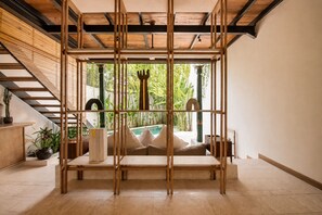 A room with a wooden partition, a staircase, and a view of a pool. - Luxurious 1-br Villa With Pool, Echo Beach 800m (Canggu)