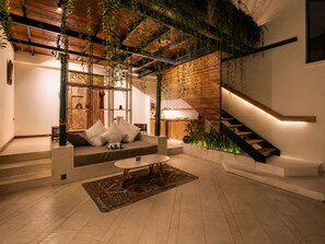 A modern interior with a staircase, a sofa, and a dining area. - Luxurious 1-br Villa With Pool, Echo Beach 800m (Canggu)