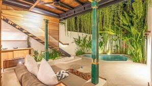 A modern indoor pool area with a wooden ceiling, a staircase, and lush greenery. - Stylish 1-br Villa With Pool, 800m to Echo Beach (Canggu)