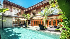 A modern pool area with a clear pool, lounge chairs, and umbrellas. - Luxury 6BR Canggu 400m to Finns Beach (Canggu)