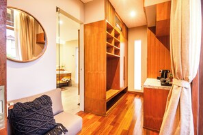 A modern room with a wooden wardrobe, a round mirror, and a small kitchenette. - Luxury 6BR Canggu 400m to Finns Beach (Canggu)