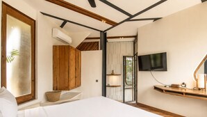 A bedroom with a bed, wooden cabinets, a TV, and a window. - Modern 1-br Loft With Art Deco Vibe Shared Pool (Canggu)