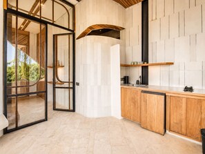 Eine moderne Küche mit einer Holzarbeitsplatte, einem eingebauten Backofen und einem großen Fenster.