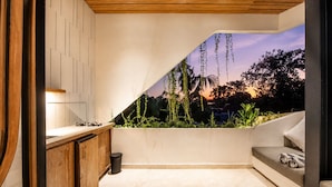 A modern kitchen with a built-in sink, wooden cabinets, and a view of a sunset through a window. - Modern 1-br Loft With Art Deco Style Shared Pool (Canggu)