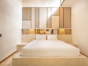 A bedroom with a bed, a large mirror, and a small table with decorative items. - Stunning 1-br Villa With Pool, Echo Beach 4mins (Canggu)