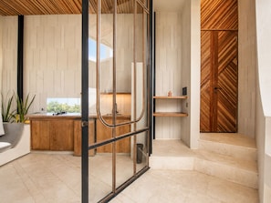 Una cocina moderna con encimera de madera, un fregadero y una ventana con vistas a la vegetación.