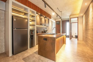 Una cucina moderna con isola centrale, elettrodomestici integrati e una parete decorativa in legno.