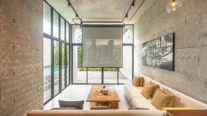 Una sala de estar moderna con un ventanal grande, una mesa de centro de madera, un sofá y vistas a la ciudad.