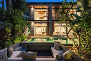 A modern house with a swimming pool, outdoor seating, and lush greenery. - Contemporary 5BR Luxury Villa 400m to the Sea (Seminyak)