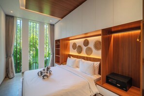 Une chambre d’hôtel moderne avec un grand lit, une tête de lit en bois et un système audio fixé au mur.