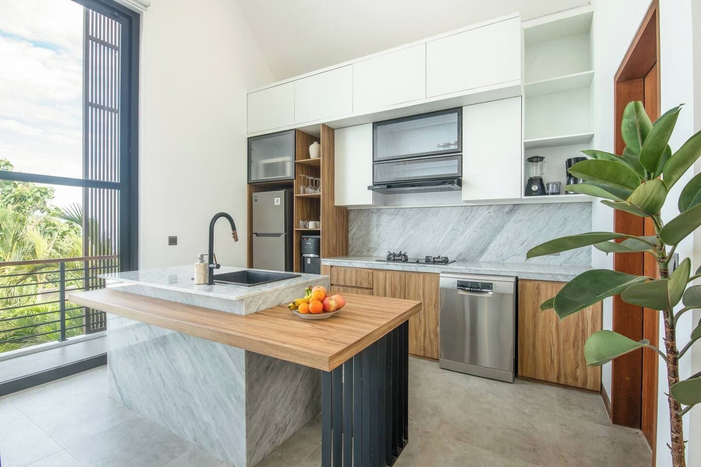 Una cocina moderna con encimera de mármol, electrodomésticos de acero inoxidable y armarios de madera.