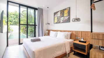 Quarto de hotel moderno com uma cama grande, cabeceira de madeira, mesa de cabeceira, um quadro e vista para uma piscina e vegetação.
