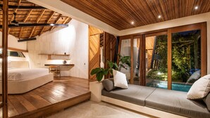A modern bedroom with a wooden ceiling, a bed, a small table, and a view of a swimming pool. - Stunning 2-br Penthouse With View 800m to Beach (Canggu)