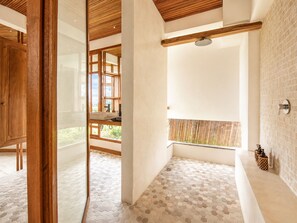 A modern bathroom with a glass door, wooden ceiling, and a shower area with a tiled floor. - Stunning 2-br Penthouse With View 800m to Beach (Canggu)
