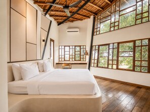 A bedroom with a bed, wooden flooring, large windows, and a sloped ceiling. - Stunning 2-br Penthouse With View 800m to Beach (Canggu)