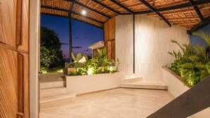 A modern outdoor area with a wooden ceiling, a white wall with a geometric pattern, and a staircase leading to a higher level. - Stunning 2-br Penthouse With View 800m to Beach (Canggu)