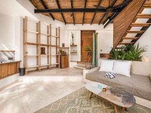 A modern living room with a sofa, coffee table, and built-in wooden shelving.