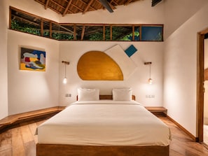 Une chambre avec un grand lit, un plafond en bois et une vue par la fenêtre.