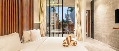 A modern hotel room with a large bed, wooden paneling on one wall, a balcony with a view, and a flat-screen TV mounted on the wall.