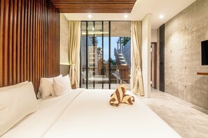 Una camera d'albergo moderna con un letto grande, pannelli di legno su una parete, un balcone con vista e un televisore a schermo piatto montato a muro.