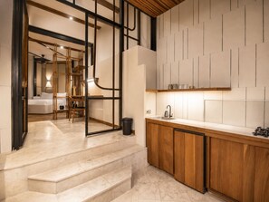 Una cocina moderna con armarios de madera, encimera de mármol y horno empotrado.