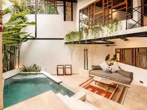 Een modern interieur met een zwembad, een bank en hangplanten.