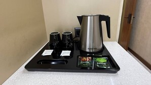 Angolo caffè con macchina da caffè, tazze e bustine di latte.