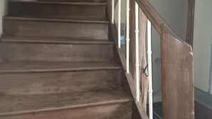 Un escalier en bois avec des balustrades blanches et une finition foncée.
