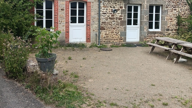 Un bâtiment en pierre doté de deux fenêtres et d’un petit balcon.