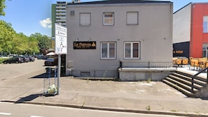 A building with a sign reading "Le Patron" and a parking sign indicating a parking area. - Le Patron Hotel (Lahr)