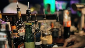 A bar counter with various bottles and a lime wedge. - Le Patron Hotel (Lahr)