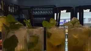 A bar area with a green tray holding four glasses of a beverage with mint leaves. - Le Patron Hotel (Lahr)