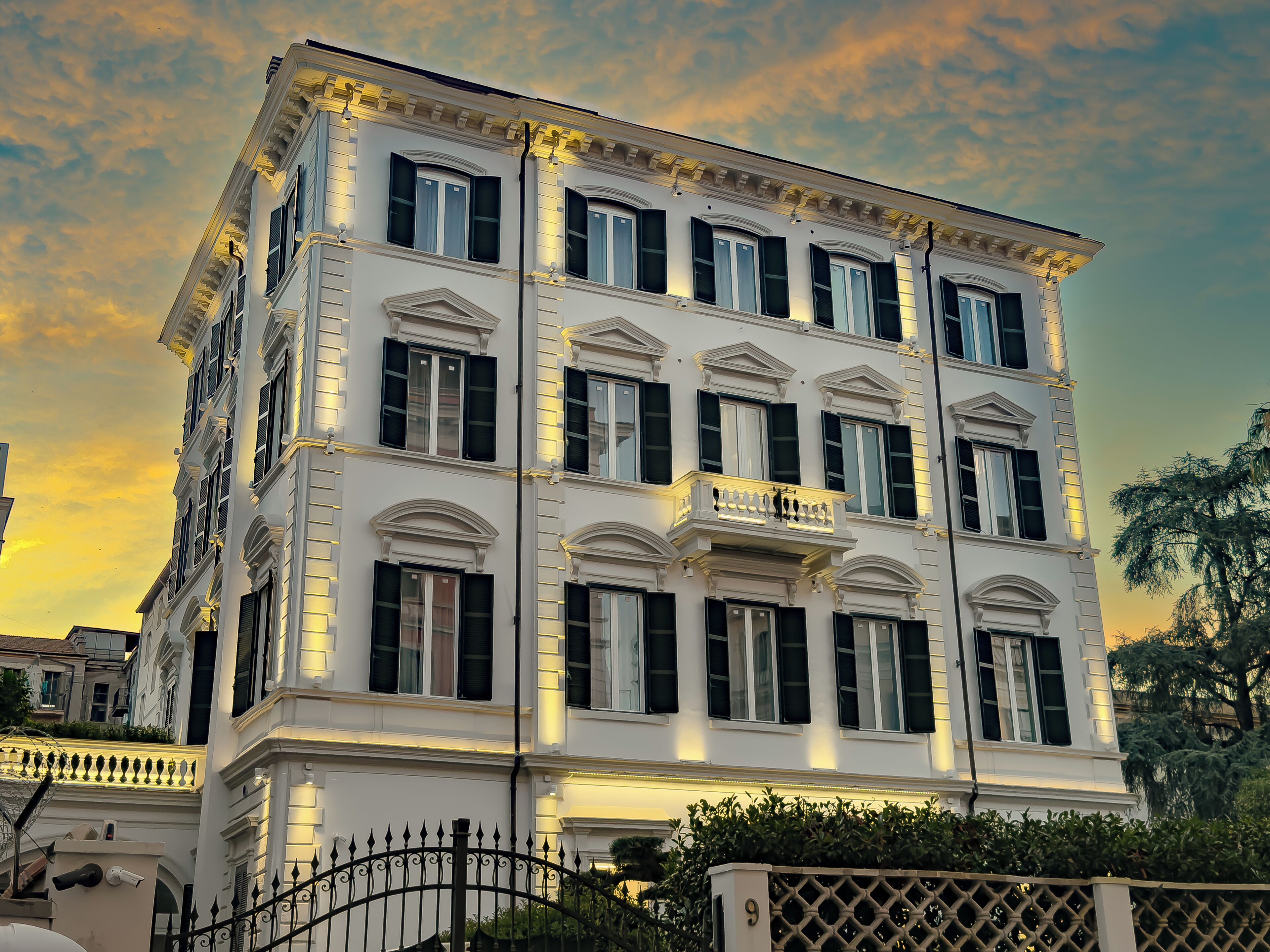 A multi-story building with a classical architectural style, featuring symmetrical windows and a balcony with railings.