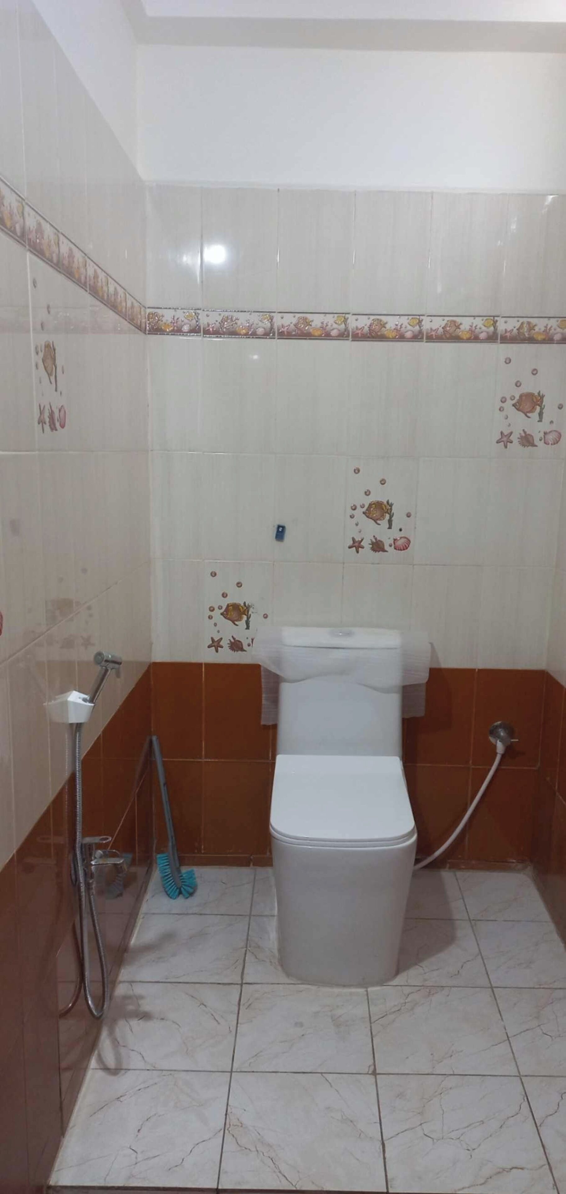 A small bathroom with a toilet, a shower, and a hand dryer.