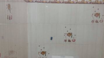 A small bathroom with a toilet, a shower, and a hand dryer.
