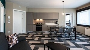 A modern apartment with a kitchen, dining area, and living room.