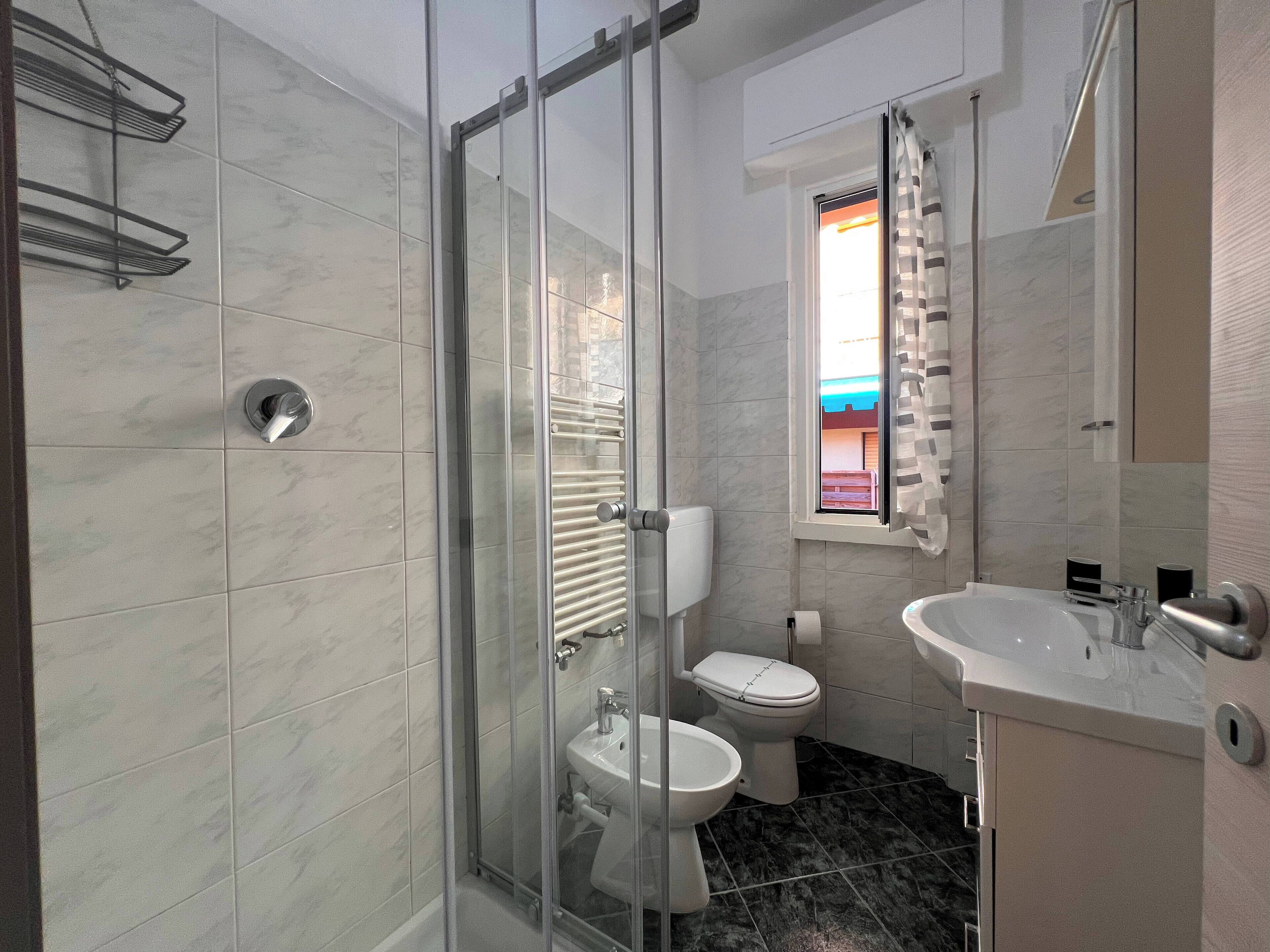 Ein modernes Badezimmer mit Duschkabine, Toilette und Waschbecken.