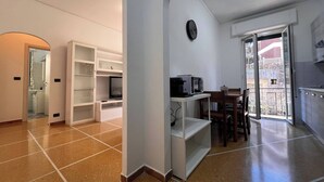 Une cuisine moderne avec des meubles blancs, un four à micro-ondes et un coin repas comprenant une table et des chaises.