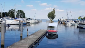 A marina with boats docked at wooden piers, calm water, and a clear sky. - Appartement Hafenflair am Plauer See (Plau am See)